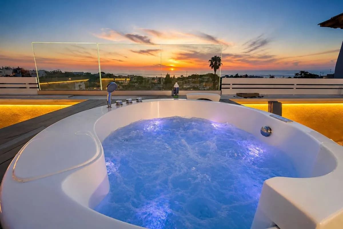 La vasca idromassaggio accesa mentre il sole tramonta sul mare